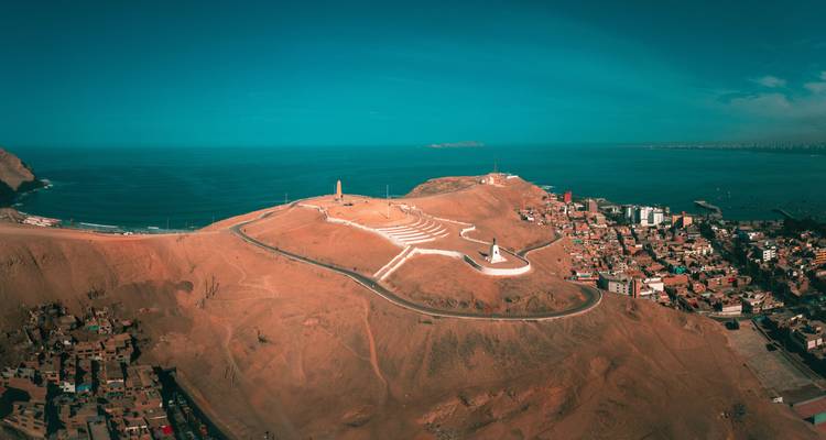 Panorama aéreo del acantilado Morro Solar que se extiende hacia el Pacífico junto a una comunidad costera extendida.