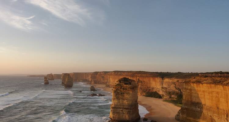 Les emblématiques formations calcaires des Douze Apôtres s'élevant des vagues turquoise au coucher du soleil.