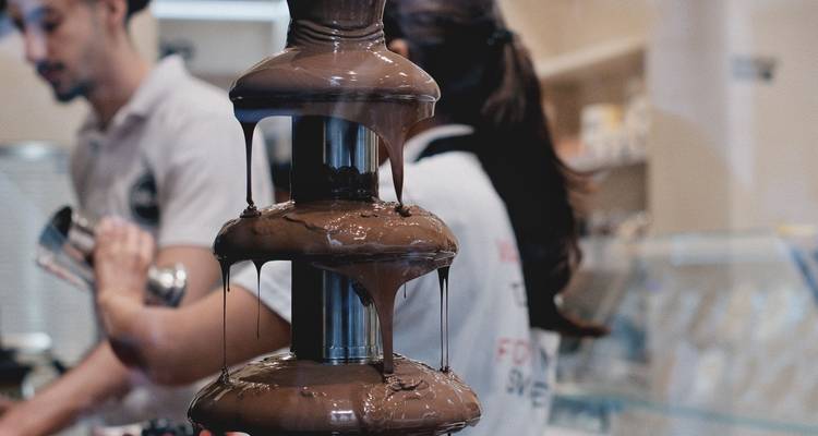 Le chocolat riche cascade le long d'une fontaine à étages multiples dans une confiserie.