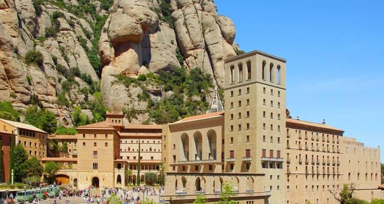 Les bâtiments couleur miel du monastère de Montserrat s'élèvent contre des falaises escarpées et dentelées, envahies de visiteurs.