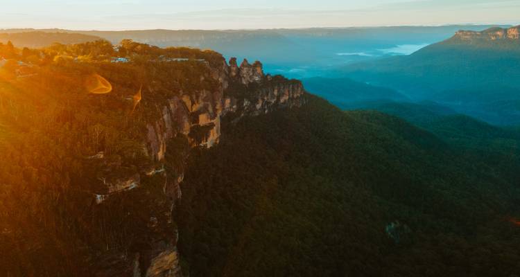 Les rayons du soleil levant illuminant le rebord de la falaise des Trois Soeurs dans les vastes Montagnes Bleues