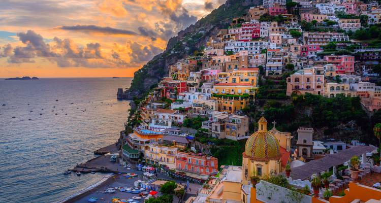 Village pittoresque de Positano aux couleurs vives, s'étendant en cascade vers la mer au coucher de soleil éclatant.