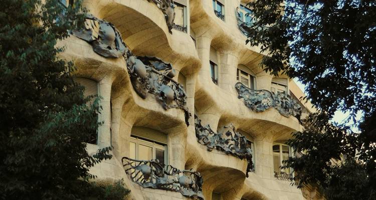 Les balcons ondulants en pierre et les détails en fer forgé de la Casa Milà vus du niveau de la rue.