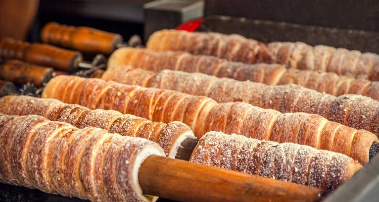Les gâteaux cheminée sucrés tournent sur des broches en bois au-dessus de braises incandescentes.