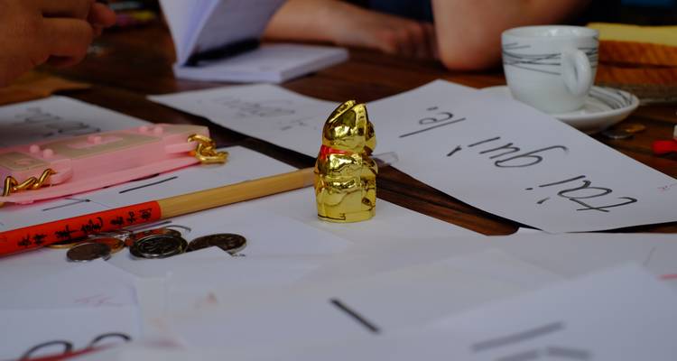 Configuration de table avec des papiers, des pièces et une petite statue de chat dorée.