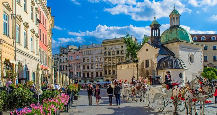Straßenansicht von Krakau mit einer Pferdekutsche und bunten Gebäuden.