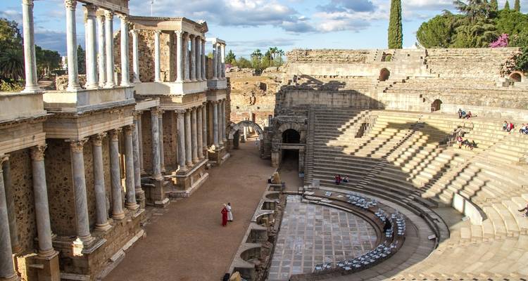 Menschen erkunden antike Amphitheater-Ruinen.