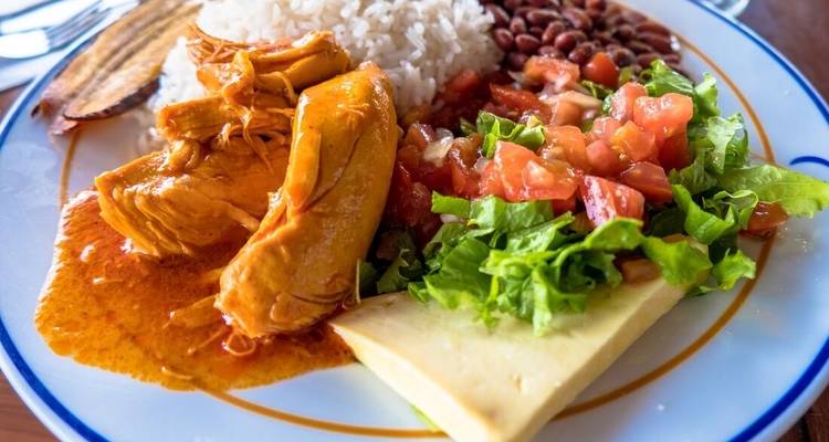 Assiette de nourriture traditionnelle avec du riz, des haricots et du poulet.