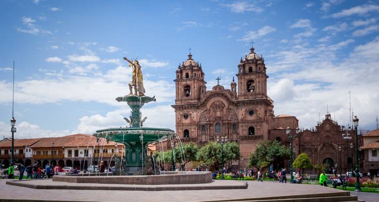 Historic fountain in city square with a church.