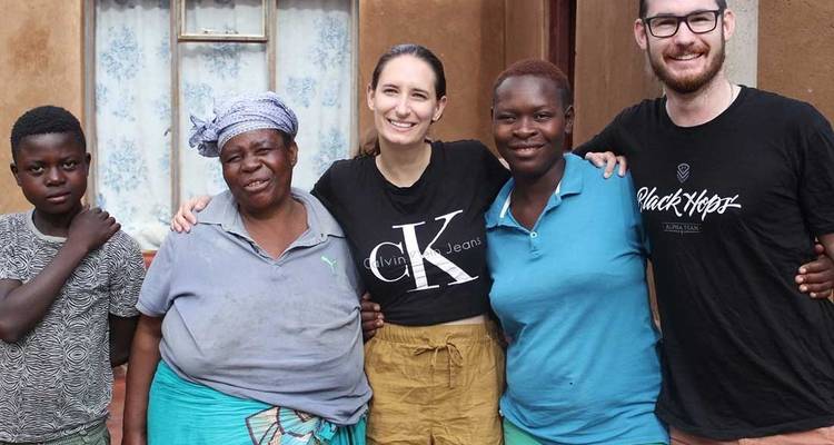 Grupo de personas posando frente a una casa.