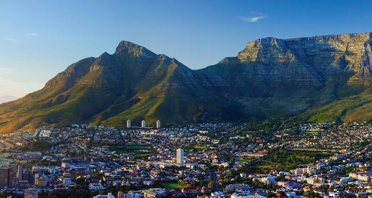 Panoramic view of a city with a mountainous backdrop.