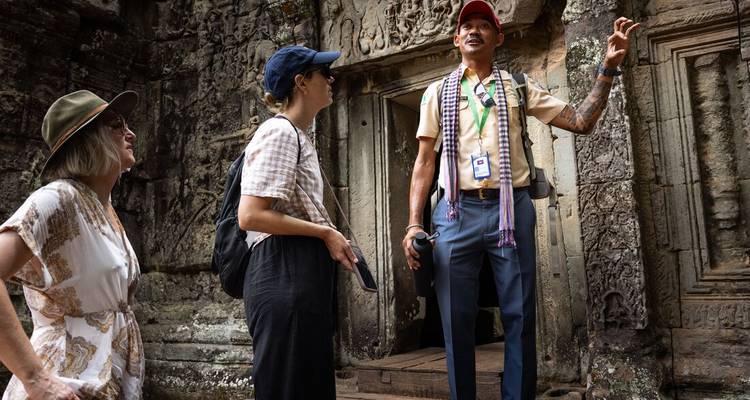 Des touristes explorant un temple ancien avec des sculptures détaillées.