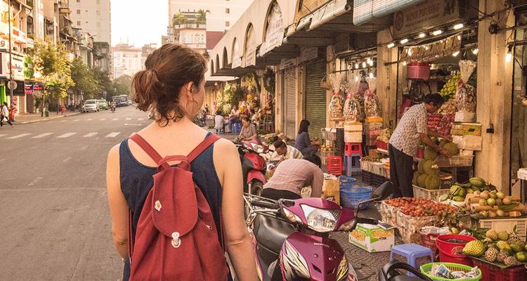 Mujer caminando por un animado mercadillo.