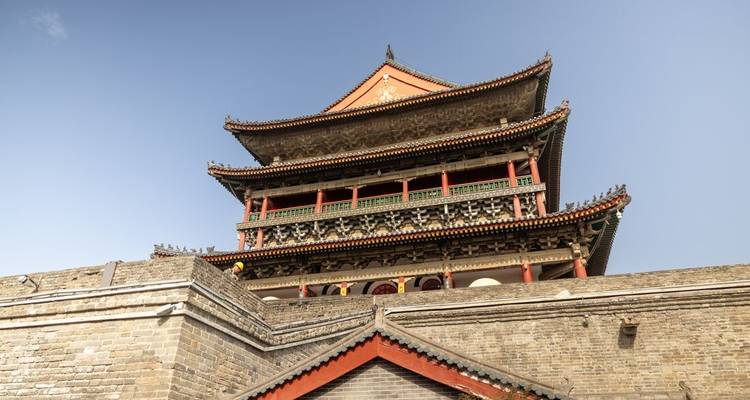 Architecture chinoise ancienne avec une tour de style pagode traditionnelle sous un ciel bleu.