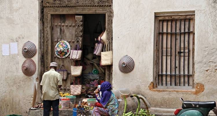 Escena de mercado con personas comprando afuera de una tienda tradicional.