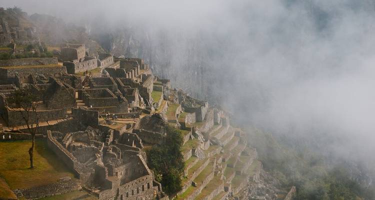 Machu Picchu ruins partially covered in mist.