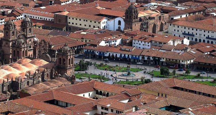 Vue aérienne de Cusco avec des bâtiments aux toits rouges.