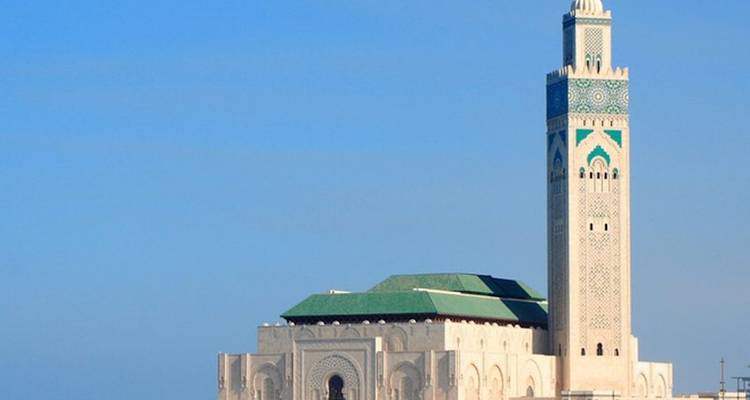 Une grande mosquée avec une architecture détaillée et un ciel bleu.