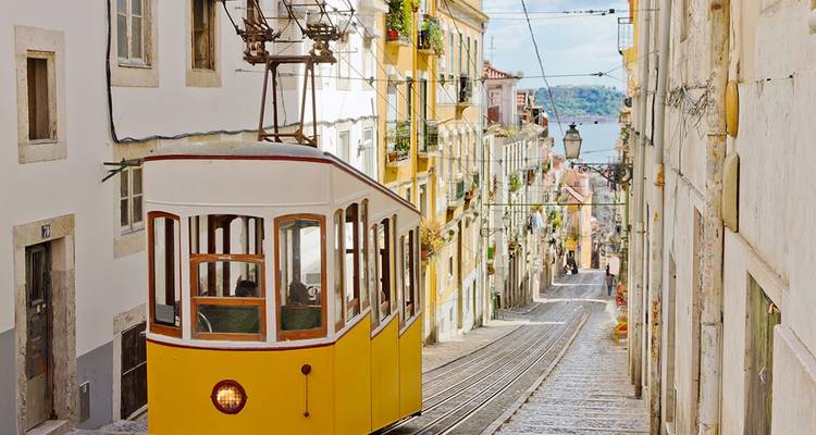A charming yellow tram on a steep street in Lisbon.