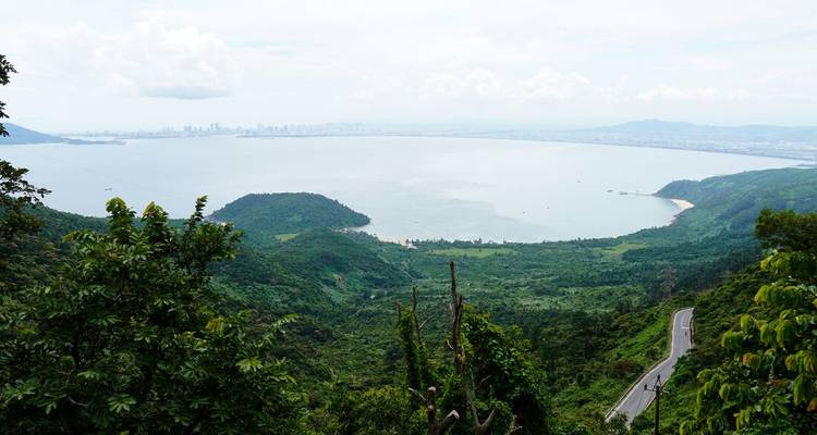 Schilderachtig uitkijkpunt met uitzicht over een grote baai en verre stad met weelderig groen.