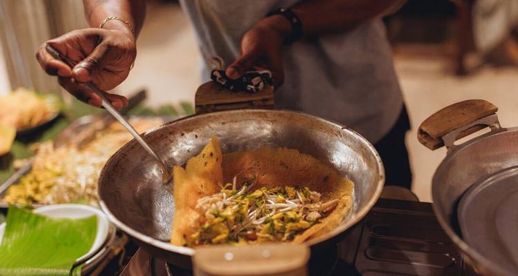 Cuisson de crêpe vietnamienne dans une poêle avec des germes et une garniture de viande