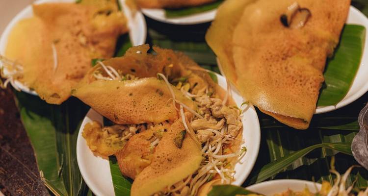 Assiettes de crêpes banh xeo fraîchement préparées servies sur des feuilles de bananier