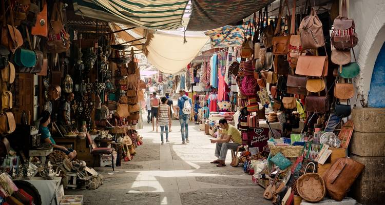 Callejón de mercado bullicioso con tiendas y compradores