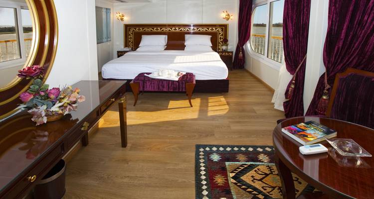 Habitación de hotel de lujo con cama de matrimonio y grandes ventanales.