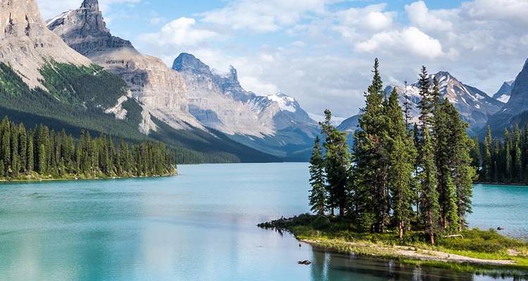 Vue époustouflante d'un lac de montagne cristallin avec une petite île de pins et un paysage montagneux environnant.