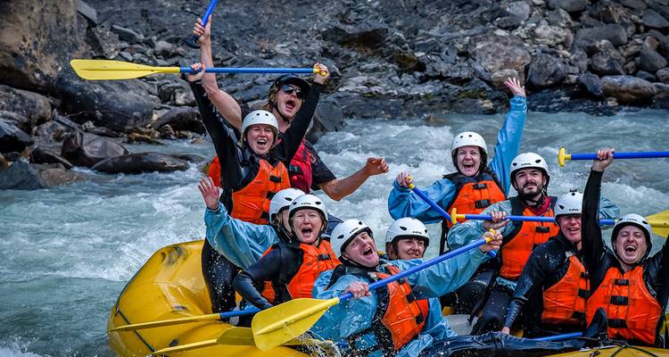 Groupe de personnes faisant du rafting en eaux vives avec enthousiasme et joie.