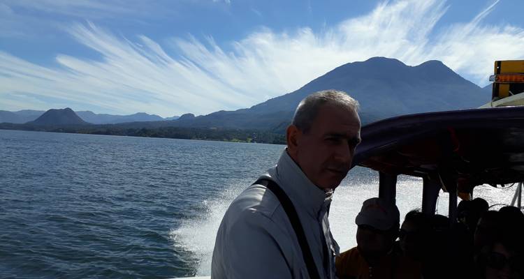 Man on a boat with mountains in the background