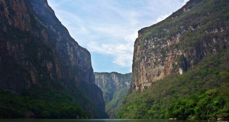 Scenic view of a river gorge with steep cliffs and lush greenery.