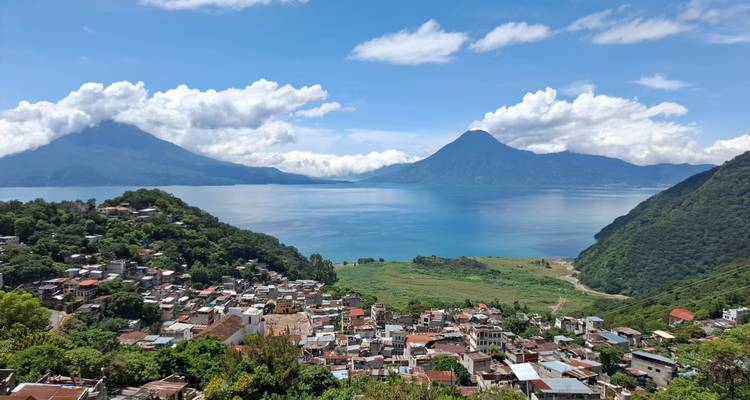 Vue panoramique d'une ville près d'un grand lac avec des volcans en arrière-plan