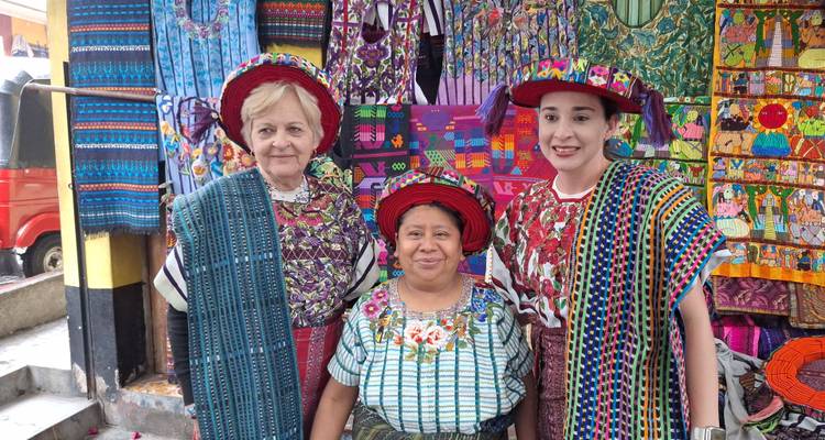Des personnes en tenues traditionnelles debout dans un marché coloré