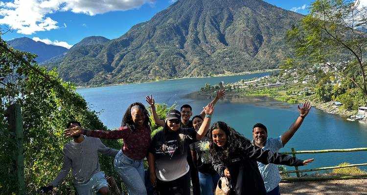 Groupe d'amis posant avec une vue sur les montagnes et un lac au Guatemala.