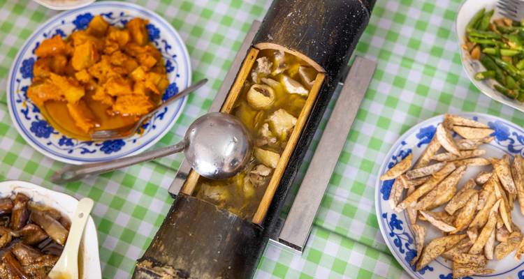Chinese maaltijden geserveerd in decoratieve kommen op een geruit tafelkleed.