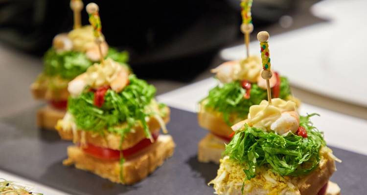 Gastronomische tapas met garnalen, groenten en sauzen op sneetjes brood