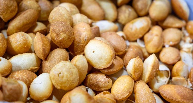 Gros plan de coques de pani puri croustillantes et dorées empilées haut dans un récipient de marché.