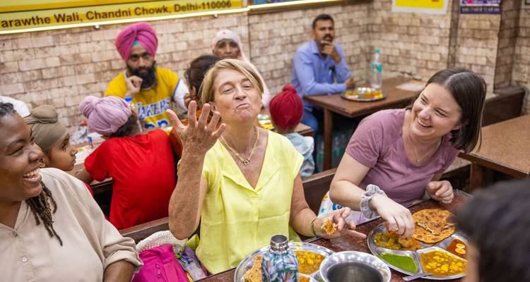 Les voyageurs rient et dégustent des plats traditionnels dans un restaurant animé de Chandni Chowk.