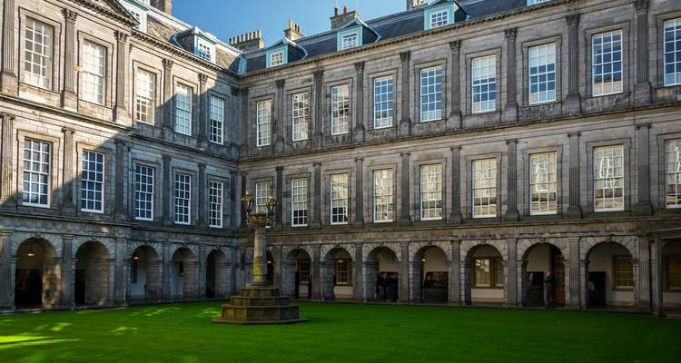 Cour intérieure d'un bâtiment historique avec une pelouse bien entretenue.