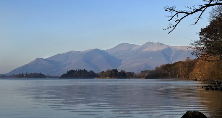 Un lac tranquille avec des montagnes en arrière-plan.