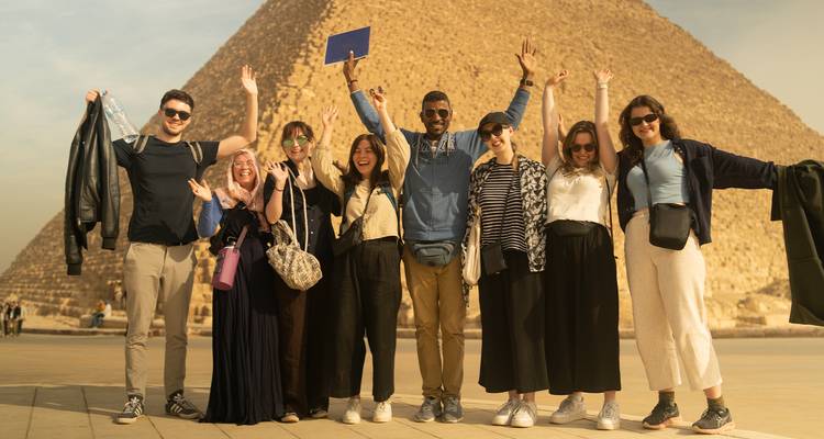 Groupe de personnes posant devant la grande pyramide de Gizeh.