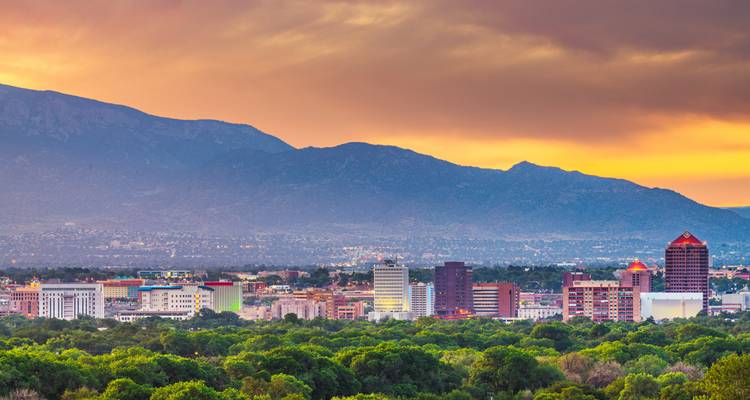 Horizonte del centro de Albuquerque con las montañas Sandia recortadas contra un cielo de atardecer vibrante