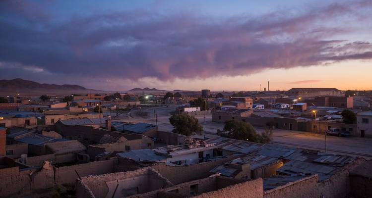 Petite ville bolivienne tranquille sous des nuages spectaculaires au crépuscule avec une lumière pourpre douce.