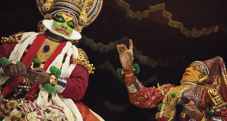 Vibrantes intérpretes de Kathakali completamente disfrazados y maquillados en el escenario durante la función