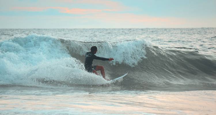 Een surfer die op een golf in de oceaan rijdt.