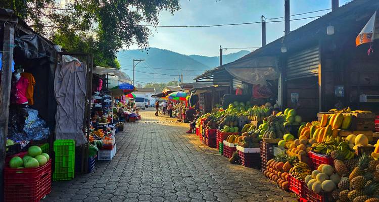 Kleurrijke groentenmarkt straat vol met fruit- en groentekraampjes onder warm licht