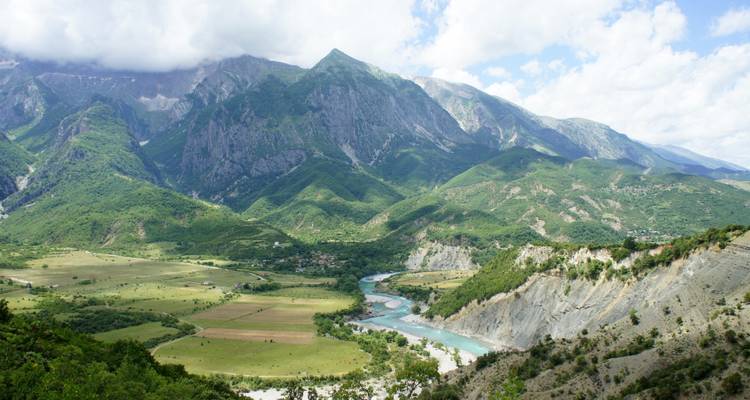 Bergige Landschaft mit einem Fluss, der sich durch das Tal schlängelt.