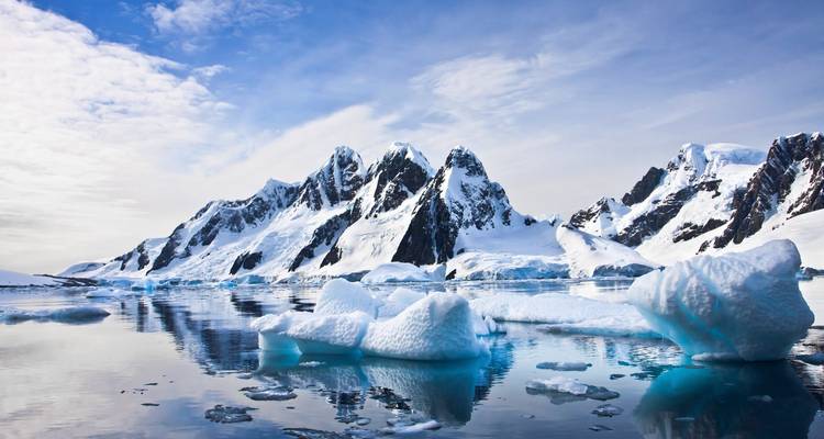 Montañas nevadas con reflejos en el agua.