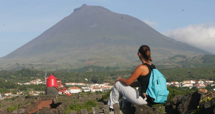 Mujer sentada contemplando una gran montaña a lo lejos.